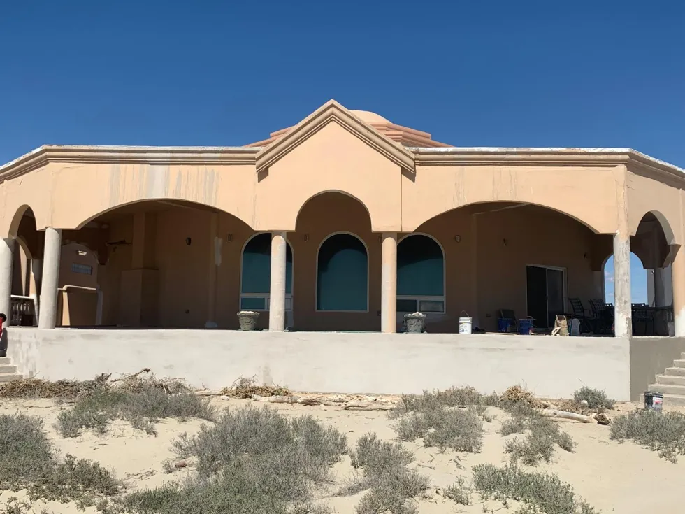 Same Rocky Point home before remodel: faded, water-stained stucco and unfinished walls